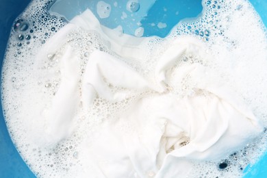 Photo of White clothes soaked in water before washing, top view