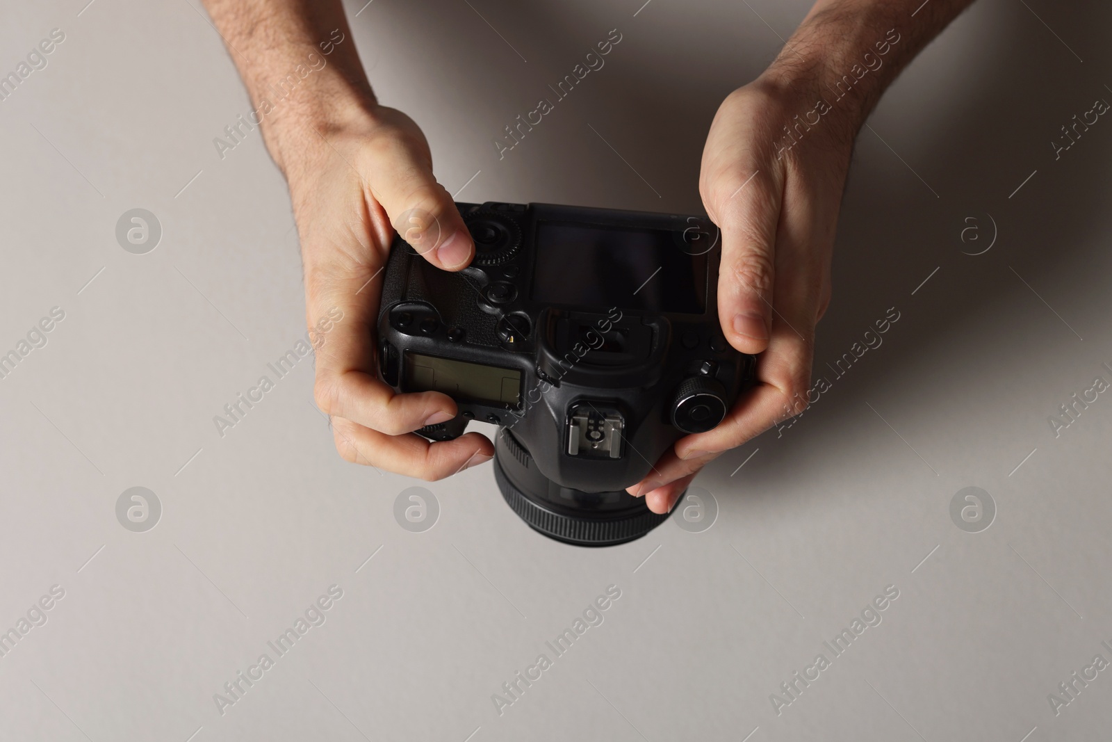 Photo of Photographer with professional camera on grey background, top view