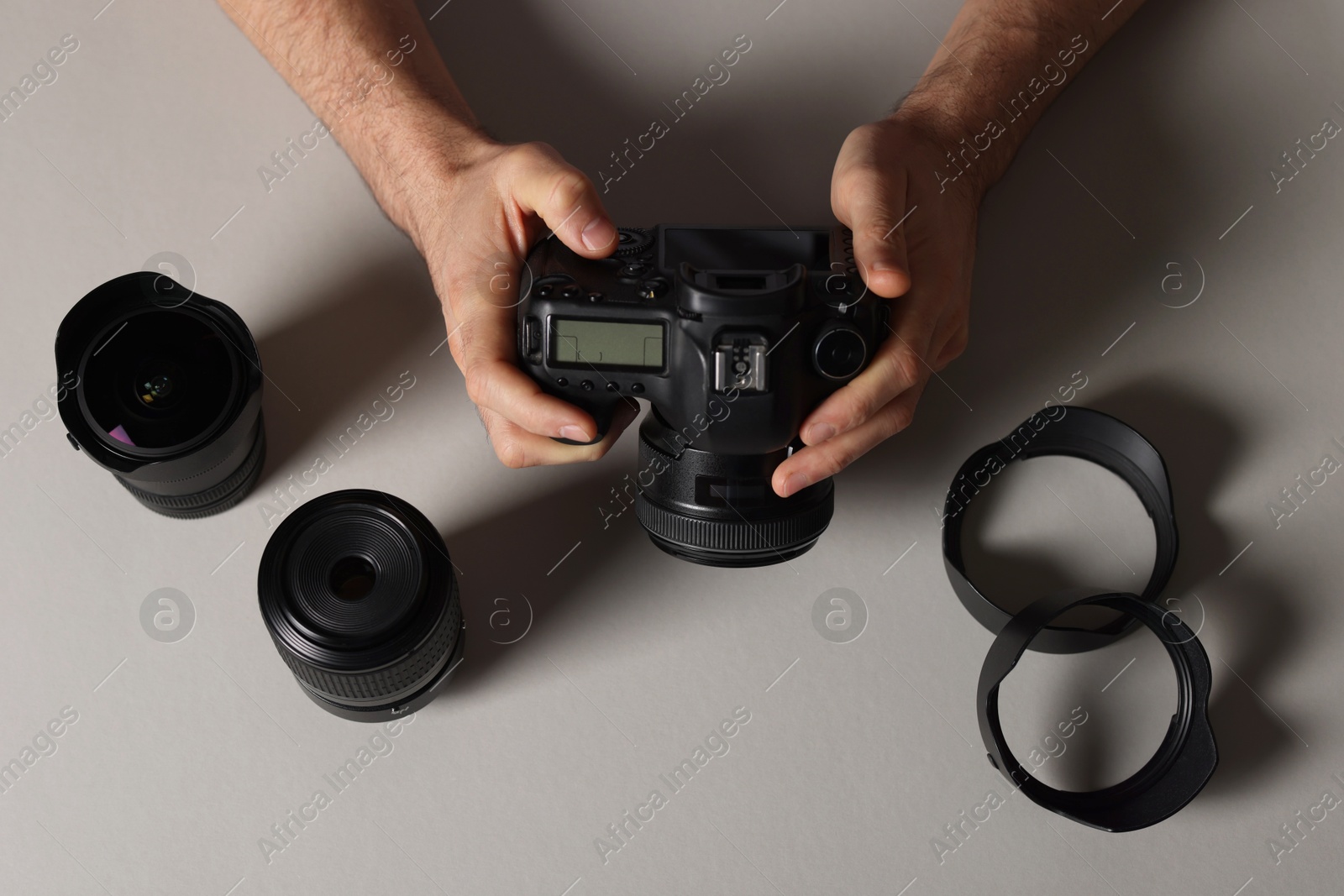 Photo of Photographer with professional camera and equipment on grey background, top view