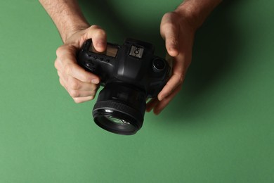 Photo of Photographer with professional camera on green background, top view