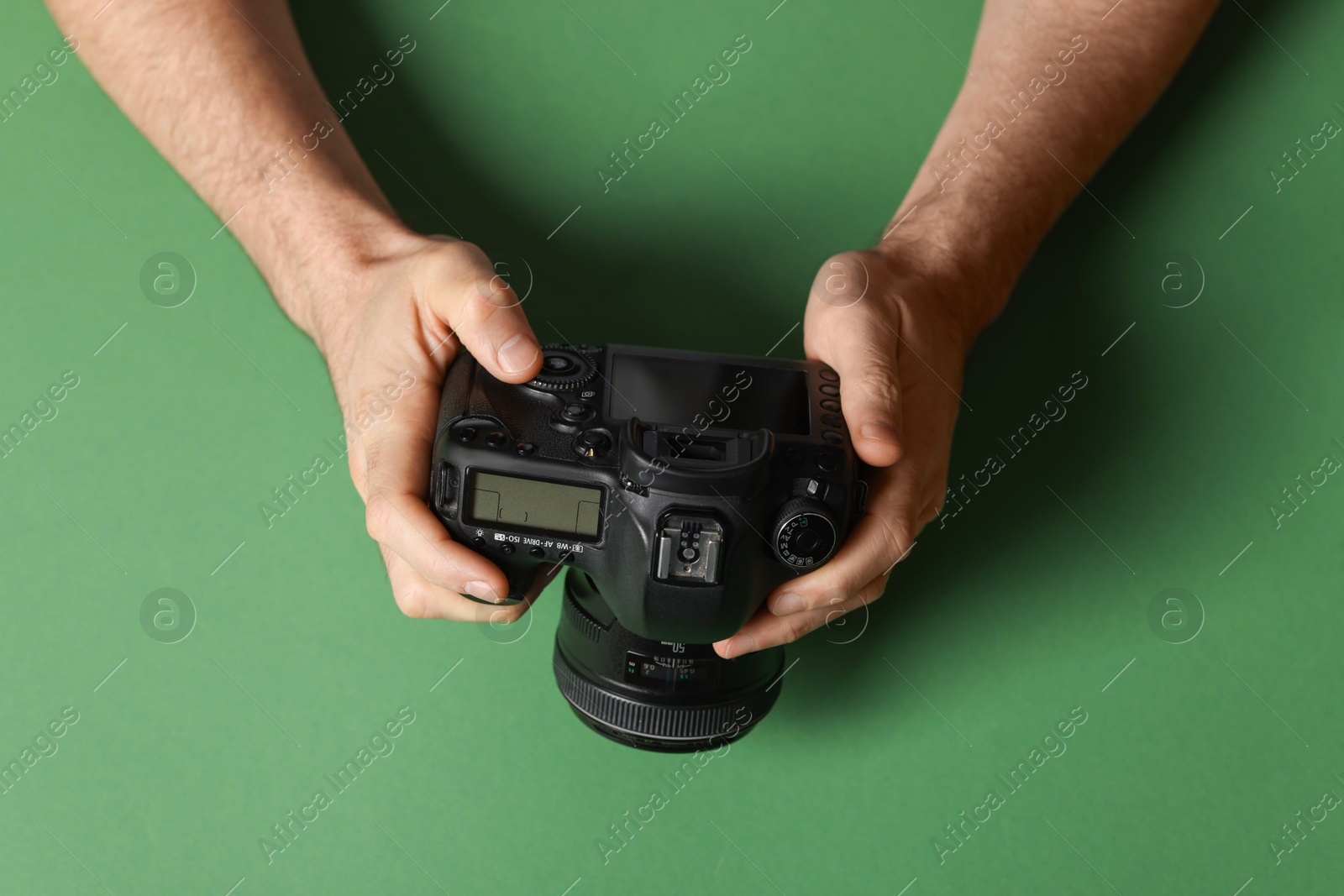 Photo of Photographer with professional camera on green background, top view