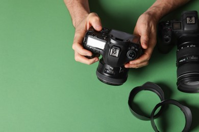 Photo of Photographer with professional camera and equipment on green background, top view. Space for text