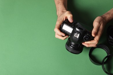 Photo of Photographer with professional camera and equipment on green background, top view. Space for text