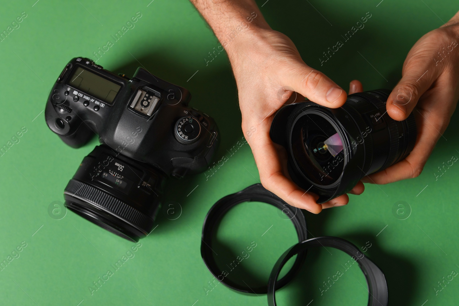 Photo of Photographer with professional camera and equipment on green background, top view