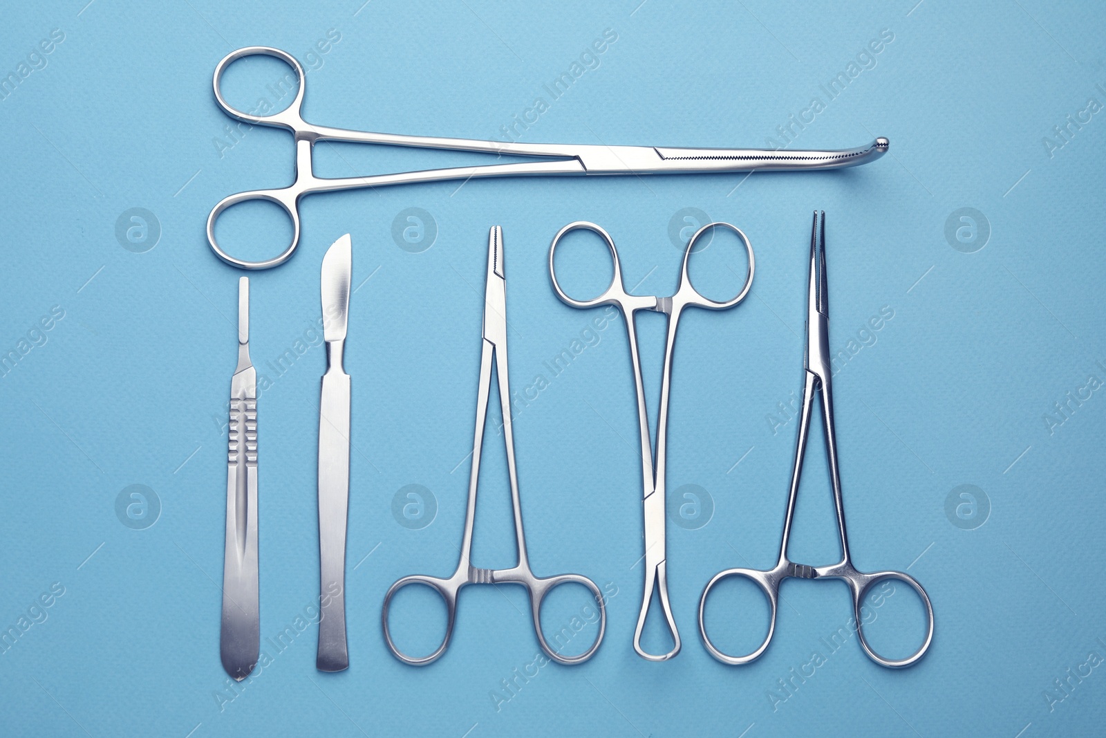 Photo of Different surgical tools on light blue background, flat lay