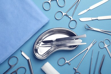 Photo of Different surgical tools on light blue background, flat lay