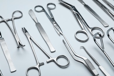 Photo of Different surgical tools on light gray background, closeup