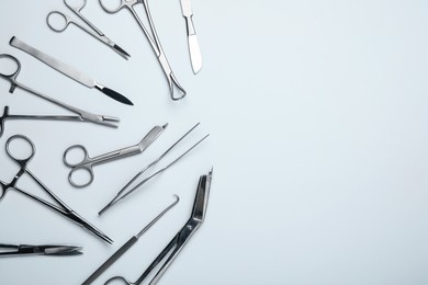 Photo of Different surgical tools on light gray background, flat lay. Space for text