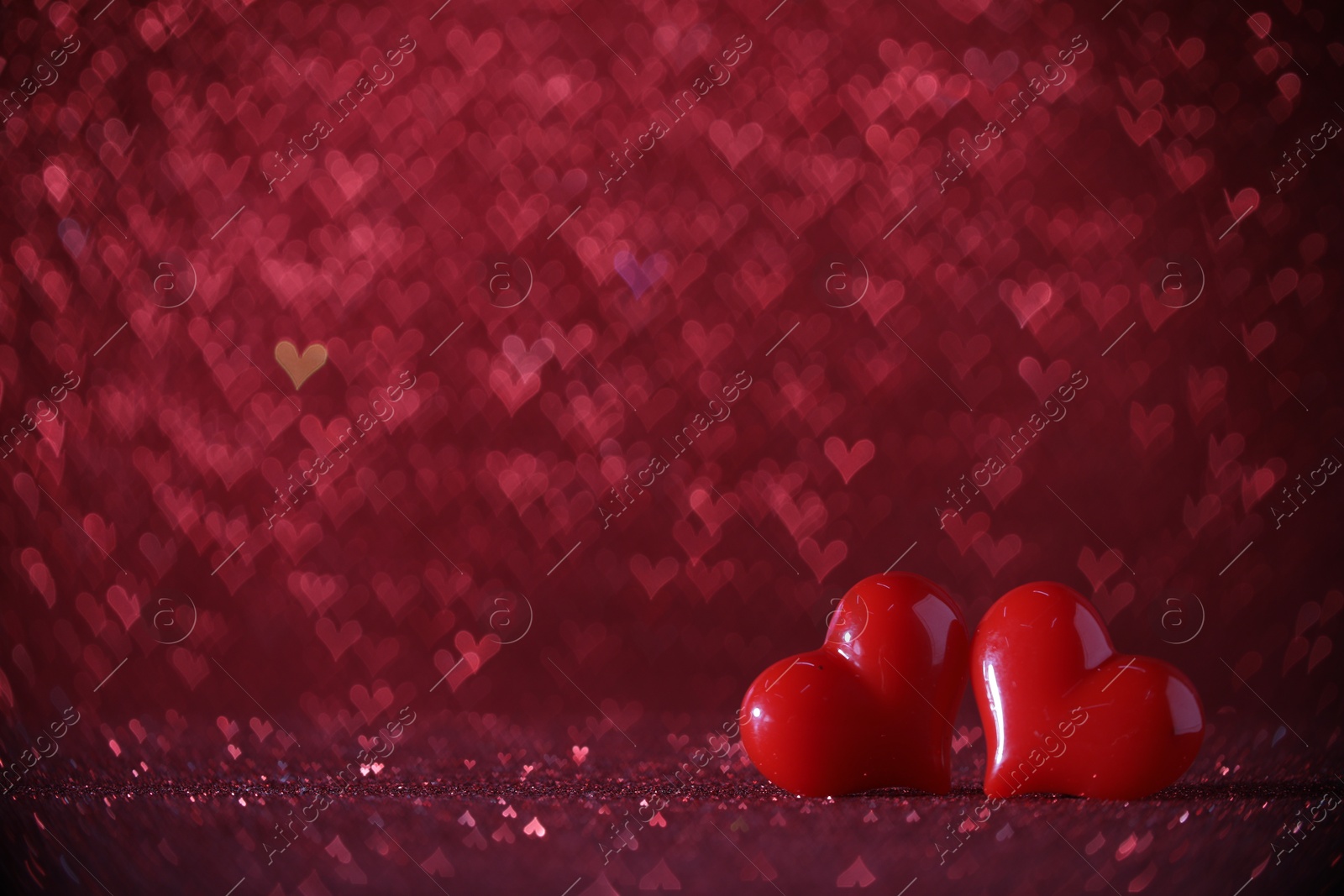 Photo of Romantic decor. Small hearts on shiny pink glitter and heart shaped lights, space for text. Bokeh effect