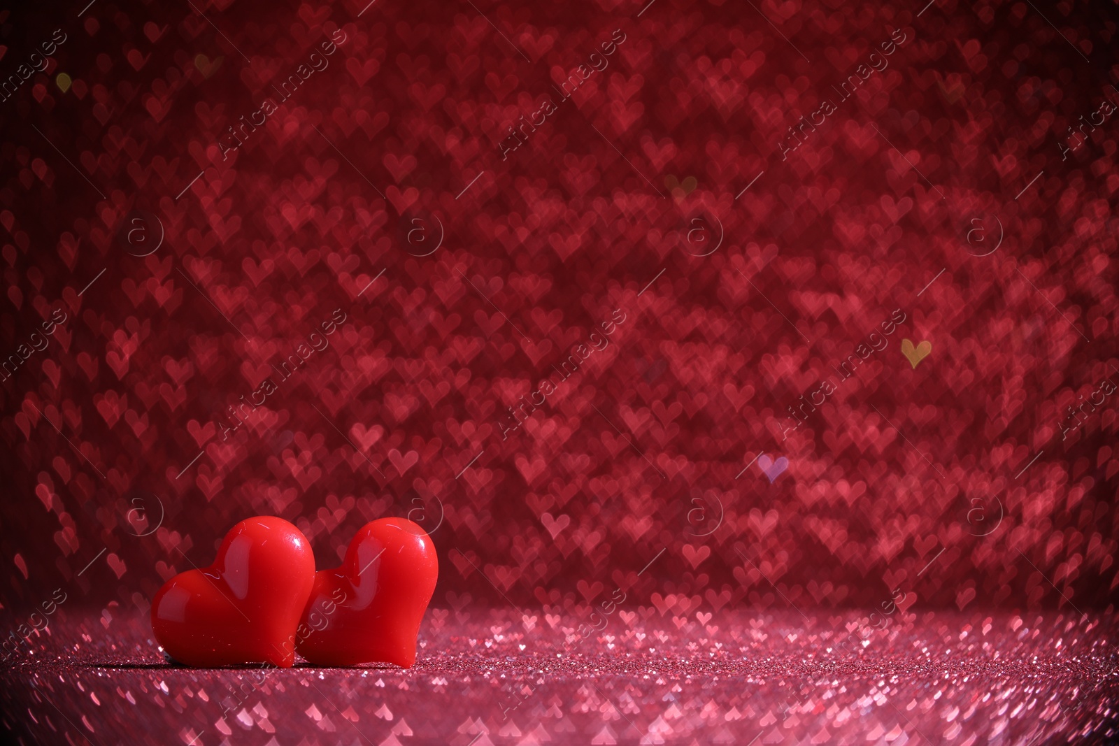 Photo of Romantic decor. Small hearts on shiny pink glitter and heart shaped lights, space for text. Bokeh effect