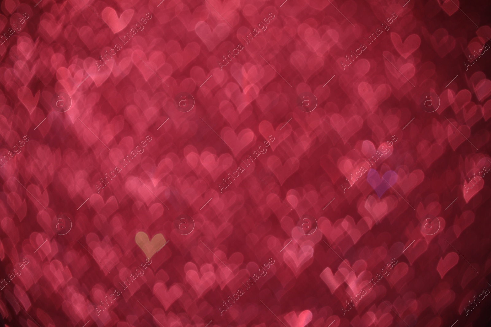 Photo of Romantic decor. Blurred view of heart shaped lights on pink background, bokeh effect