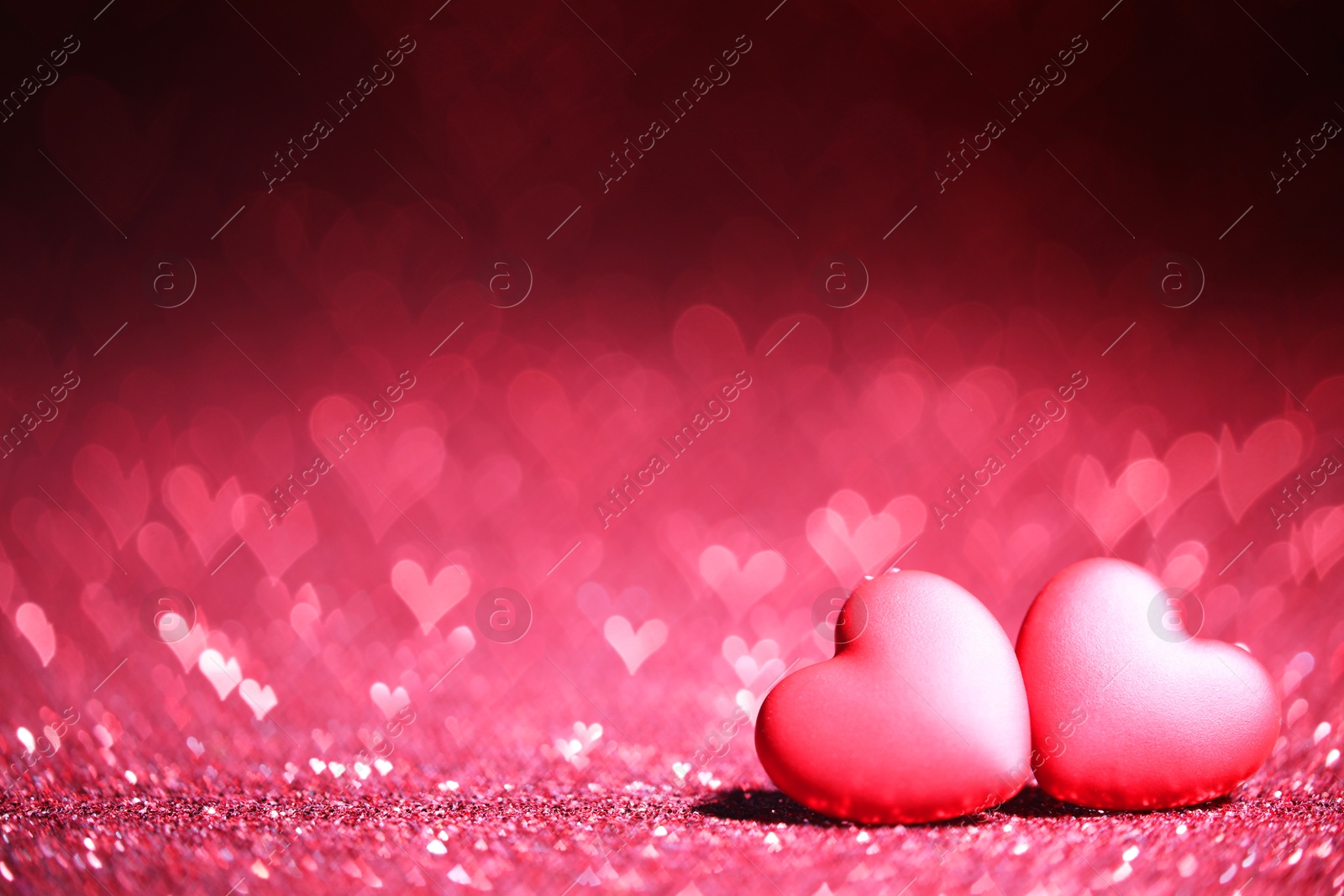 Photo of Romantic decor. Small hearts on shiny pink glitter and heart shaped lights, space for text. Bokeh effect