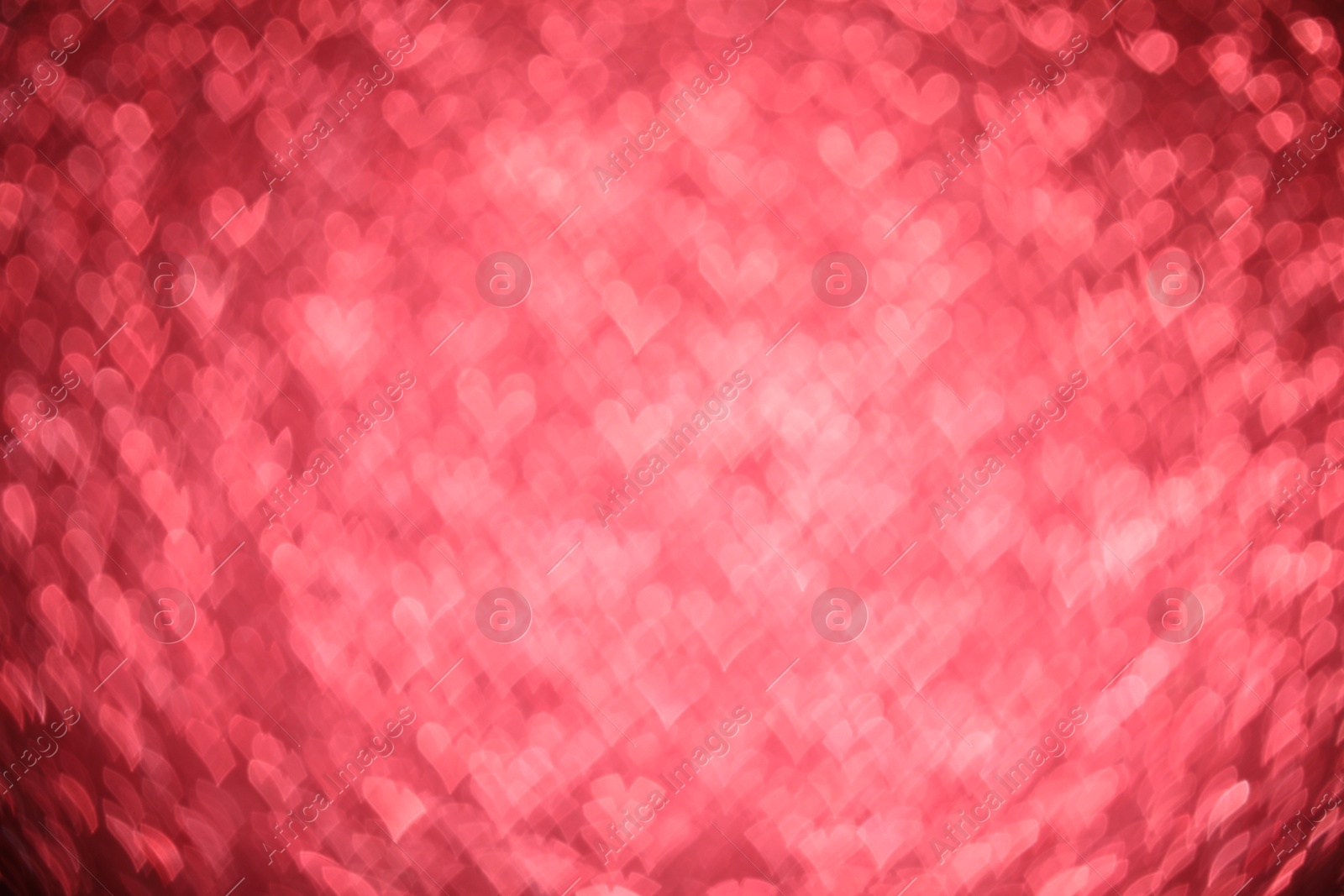 Photo of Romantic decor. Blurred view of heart shaped lights on red background, bokeh effect