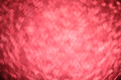 Photo of Romantic decor. Blurred view of heart shaped lights on red background, bokeh effect