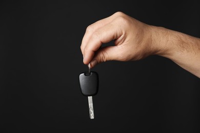 Photo of Man with car key on black background, closeup. Space for text