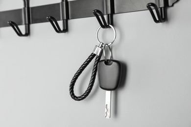 Car key on hanger against grey wall