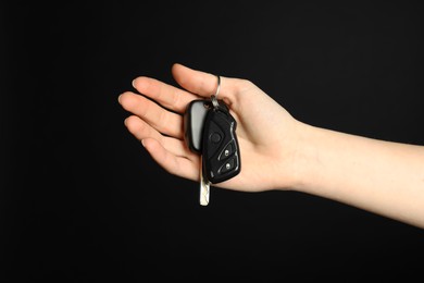 Photo of Woman with car keys on black background, closeup