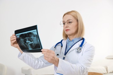 Doctor with glasses examining x-ray picture in clinic