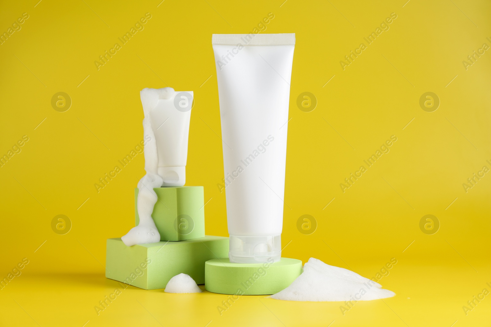 Photo of Presentation of cosmetic products with foam on yellow background