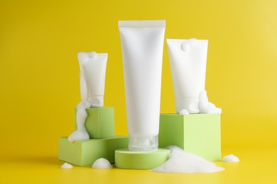 Presentation of cosmetic products with foam on yellow background