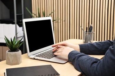 Photo of Woman working on computer at desk indoors, closeup