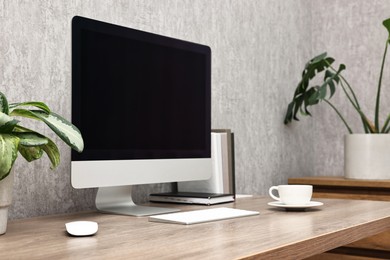 Photo of Comfortable workplace with modern computer on wooden table indoors