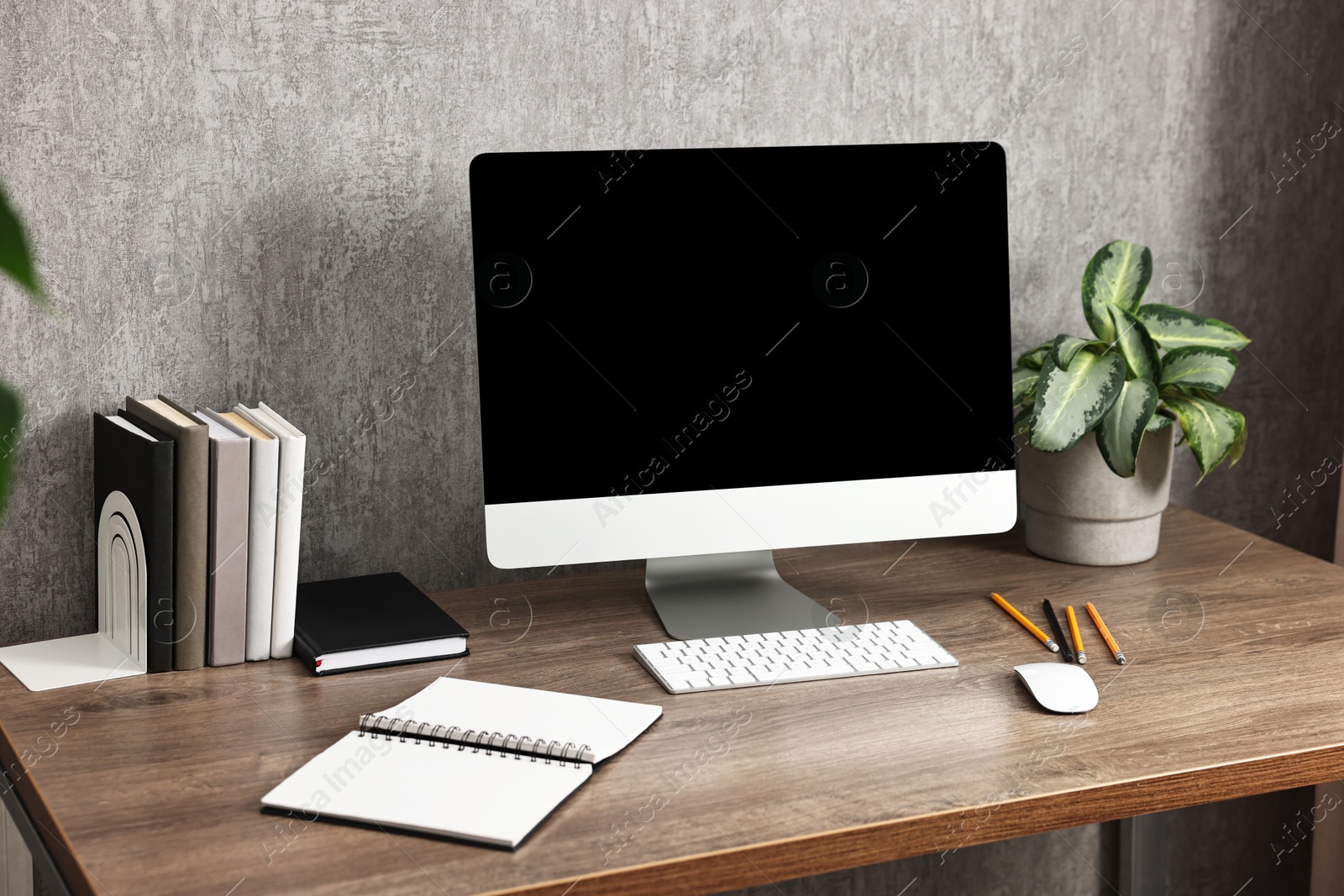 Photo of Comfortable workplace with modern computer on wooden table indoors