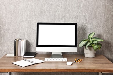 Photo of Comfortable workplace with modern computer on wooden table indoors