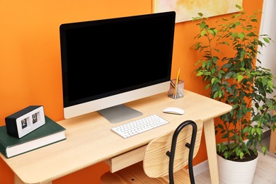 Photo of Comfortable workplace with modern computer on wooden table indoors