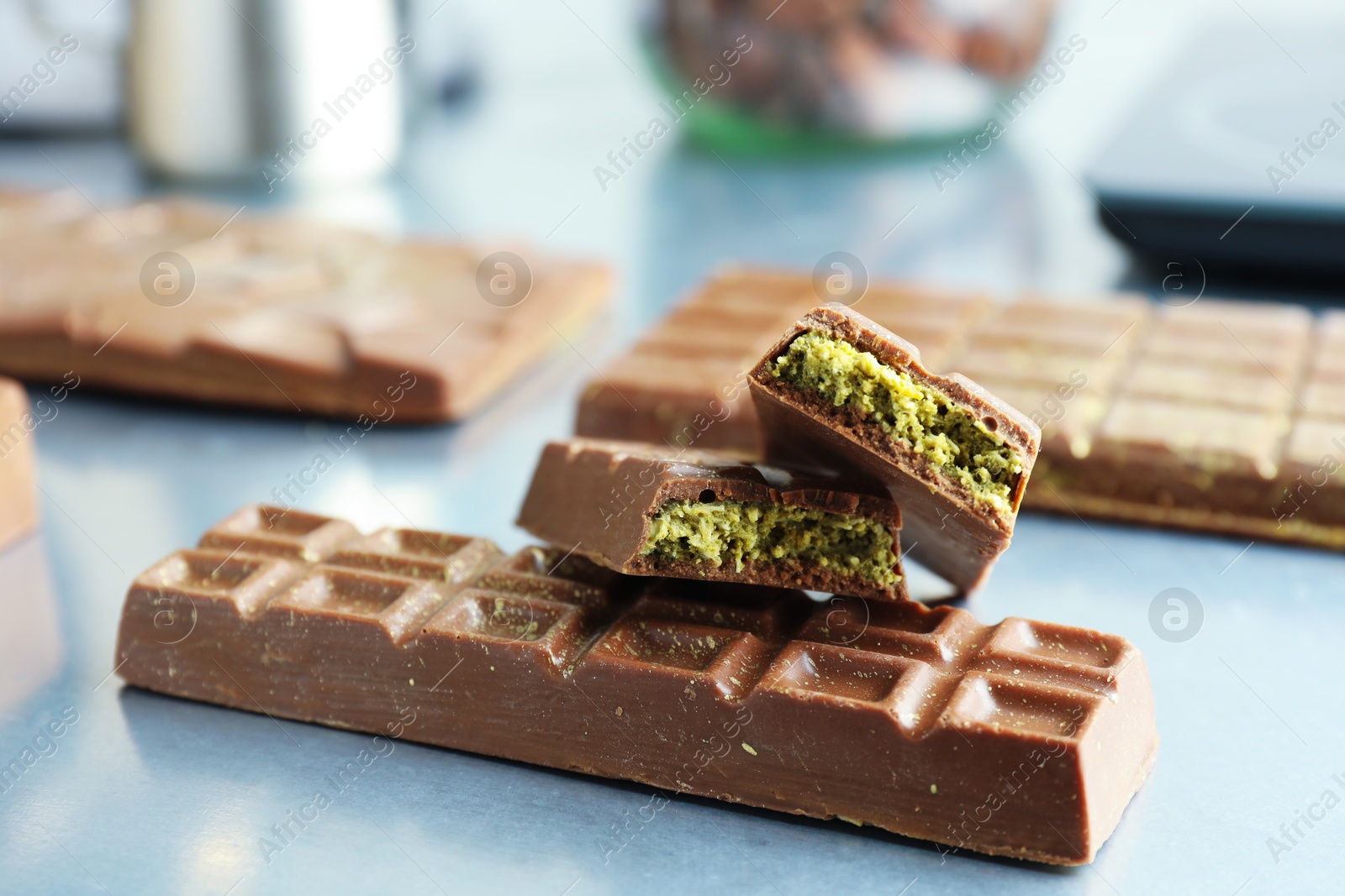 Photo of Tasty Dubai chocolate with pistachios and knafeh on grey table, closeup