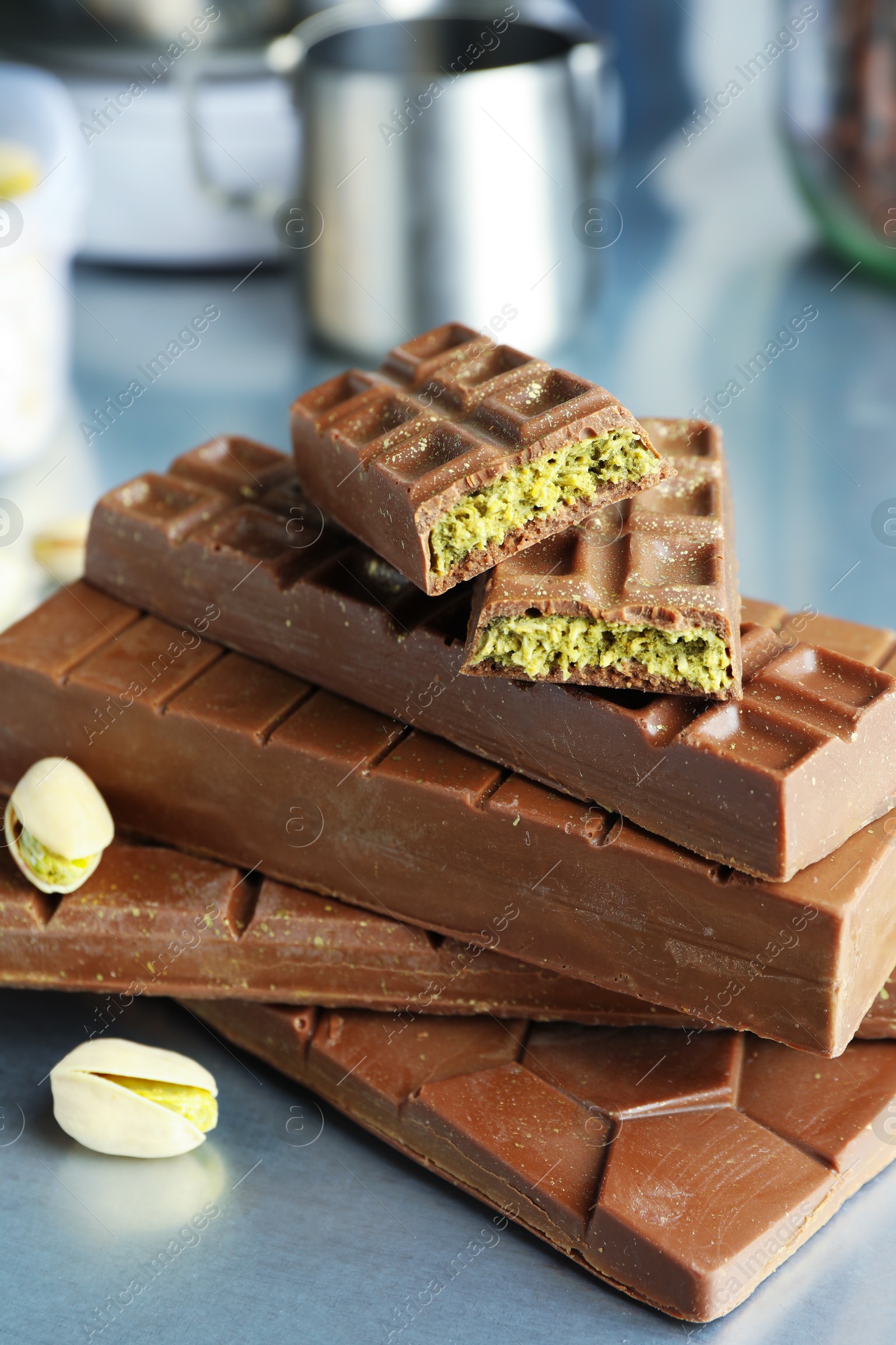 Photo of Stack of tasty Dubai chocolate bars with pistachios and knafeh on grey table, closeup