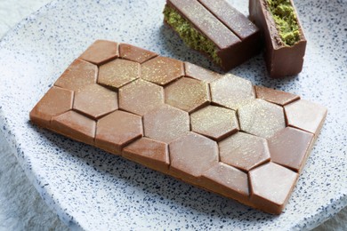 Delicious Dubai chocolate with pistachios and knafeh on table, closeup