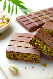 Pieces of delicious Dubai chocolate with pistachios and knafeh on table, closeup