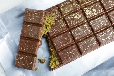 Photo of Delicious Dubai chocolate with pistachios and knafeh on table, top view