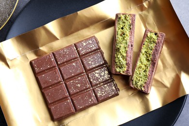 Photo of Pieces of delicious Dubai chocolate with pistachios and knafeh on table, top view