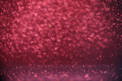 Photo of Shiny pink glitter and blurred heart shaped lights on background, bokeh effect. Romantic decor