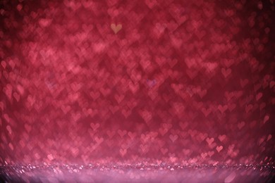 Photo of Shiny pink glitter and blurred heart shaped lights on background, bokeh effect. Romantic decor