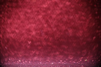 Photo of Shiny pink glitter and blurred heart shaped lights on background, bokeh effect. Romantic decor