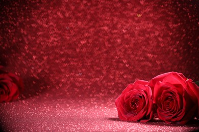 Photo of Romantic decor. Beautiful roses on shiny pink glitter and heart shaped lights, space for text. Bokeh effect