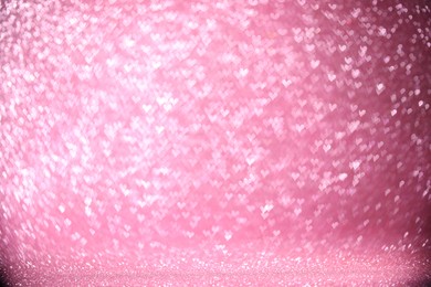 Photo of Shiny pink glitter and blurred heart shaped lights on background, bokeh effect. Romantic decor