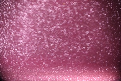 Photo of Shiny pink glitter and blurred heart shaped lights on background, bokeh effect. Romantic decor