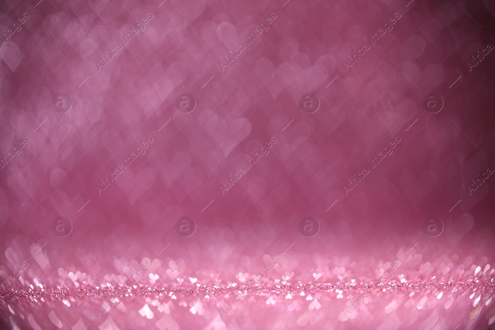 Photo of Shiny pink glitter and blurred heart shaped lights on background, bokeh effect. Romantic decor