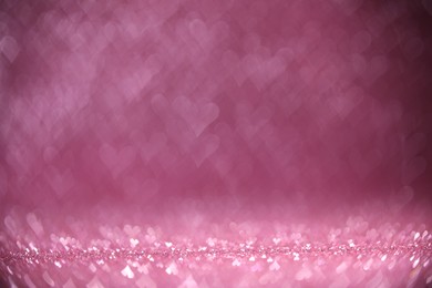 Photo of Shiny pink glitter and blurred heart shaped lights on background, bokeh effect. Romantic decor