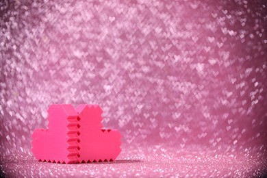 Photo of Romantic decor. Small hearts on shiny pink glitter and heart shaped lights, space for text. Bokeh effect