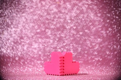 Photo of Romantic decor. Small hearts on shiny pink glitter and heart shaped lights, space for text. Bokeh effect