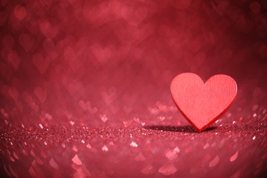 Photo of Romantic decor. Wooden heart on shiny red glitter and bokeh lights, space for text