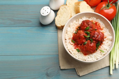 Photo of Tasty meatballs with sauce, rice and products on light blue wooden table, flat lay. Space for text