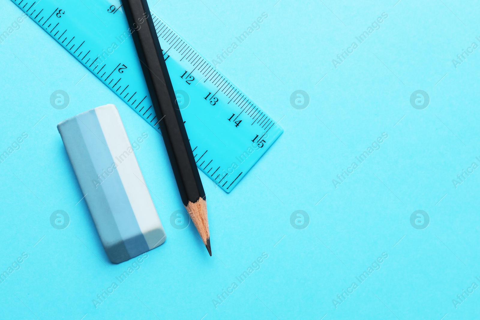 Photo of Eraser, pencil and ruler on light blue background, top view. Space for text