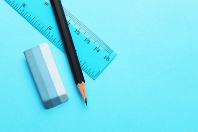 Photo of Eraser, pencil and ruler on light blue background, top view. Space for text