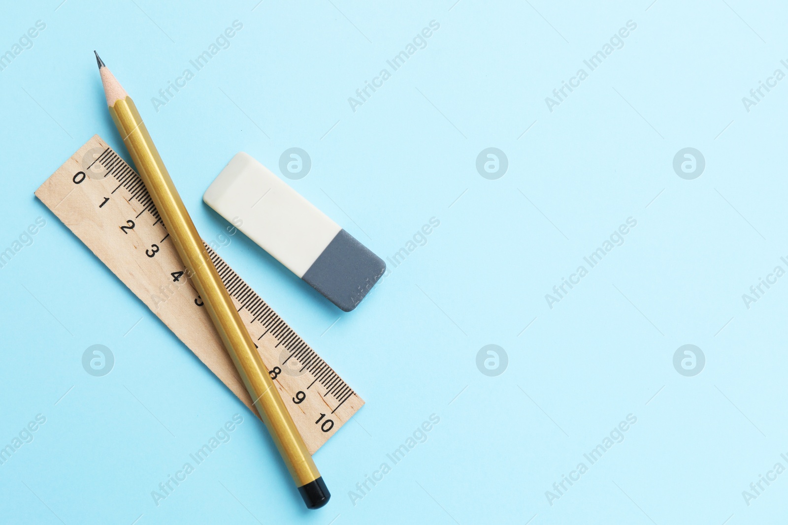 Photo of Eraser, pencil and ruler on light blue background, top view. Space for text